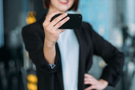 Social media addiction. Closeup of female hand holding smartphone. Narcissistic lady taking selfie. Modern technologies.の写真素材
