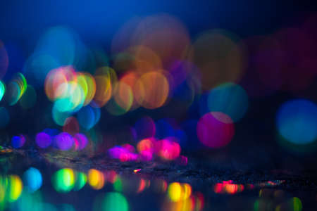Distant blurred spots. Night city lights background. Faded lens flare colorful backdrop.の写真素材