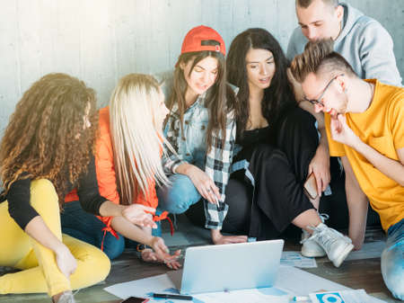 Millennials business life. Young team sitting on floor, discussing project improvement, brainstorming, looking for solution.