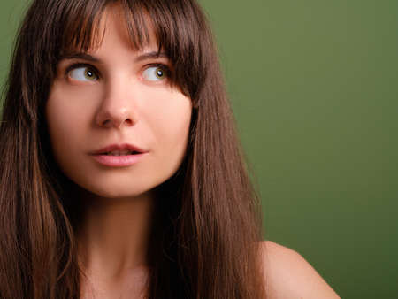 Surprised cute young lady. Interested facial expression. Closeup portrait of emotional brunette girl.の写真素材