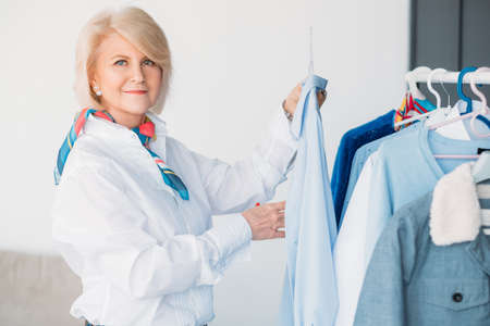 Personal style consultant. Modern senior woman. Business, hobby and lifestyle. Fashion stylist at work choosing outfit.の写真素材