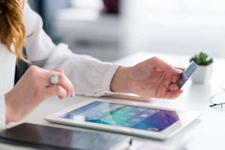 E-commerce payment. Online banking. Woman with tablet and credit card making transaction. Safe and...