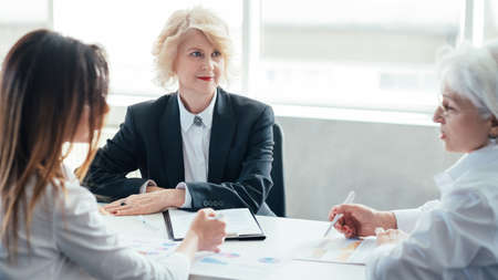 Successful business women at meeting. Financial report. Mature female boss reviewing sales performance. Female oriented company.の写真素材