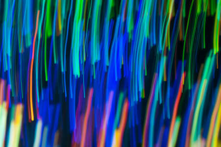 Blurry abstract background with wavy multicolor lines. Neon lights in motion. Defocused lens flare glow.の写真素材