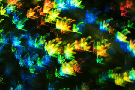 Blurred neon lights in motion. Swirled thin multicolor lines on dark background. Lens flare effect.