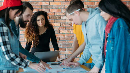 Business team meeting. Project strategy analysis. Millennials discussing marketing plan. Creative ideas of diverse group.の写真素材