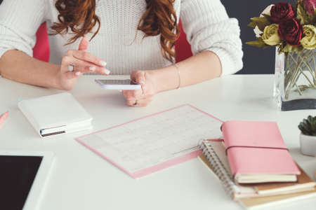 Social network business. Internet marketing. SMM woman at workplace browsing smartphone. Schedule...