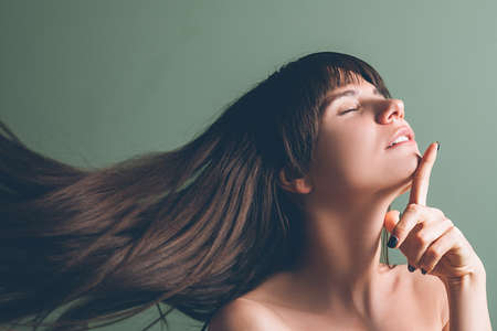 Professional care cosmetic products. Closeup portrait of emotional brunette girl relaxed after hair treatment in beauty salon.の写真素材