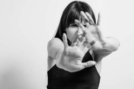 Stop domestic violence. Refusal rejection and denial gesture. Black and white portrait of woman putting palm hand forwardの写真素材