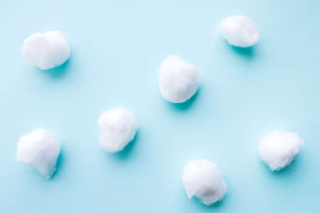 Dentistry concept. Flat lay of teeth like cotton balls on blue surface. Abstract background.の写真素材