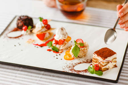 Dessert degustation. Wedding menu. Restaurant buffet food. Gastronomy cakes assortment on white plate.の写真素材