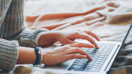 Remote job. Freelance technical content writer. Woman working from home. Closeup of female hands typing on laptop.の写真素材