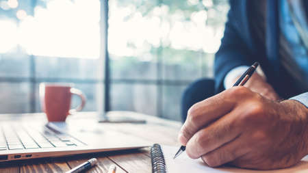 Successful business man. Corporate lifestyle. Powerful leader working at modern office. Closeup of male hand taking notes.の写真素材