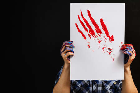 Visual arts class. Hobby lifestyle. Artist imagination creativity. Artistic workshop. Poster in man hands, red brush strokes on.の写真素材