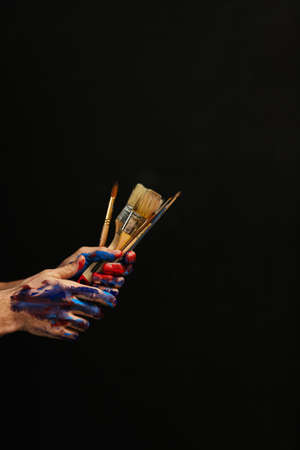 Art class school courses. Man hands paint on holding bunch of paintbrushes. Basic supplies for...
