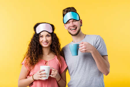 Good morning. Happy young couple in strong relationship. Pretty lady and handsome man starting their day together with coffee.の写真素材