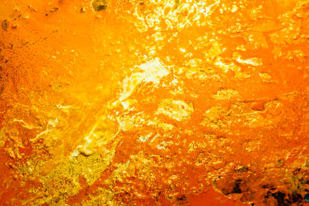 Abstract yellow orange color background. Acrylic paint liquid fluid mix blend. Art effect technique. Smooth glowing surface.の写真素材