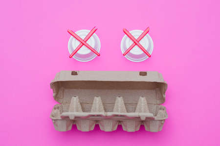Stop plastic pollution. Zero waste lifestyle. Garbage monster made of carton egg box and disposable cups on pink background.の写真素材