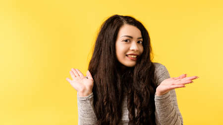 Portrait of cute brunette girl. Funny emotional lady making innocent facial expression, indifferent gesture. Copy space.の写真素材