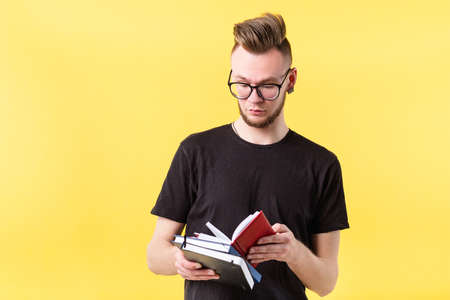 Portrait of self organized, confident young hipster guy focused on reviewing notes in pocketbook....