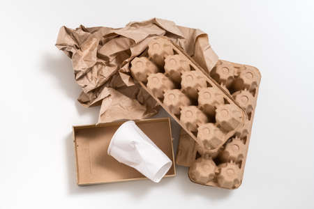 Eco friendly material. Biodegradable waste. Paper boxes and cup arranged on white surface.の写真素材