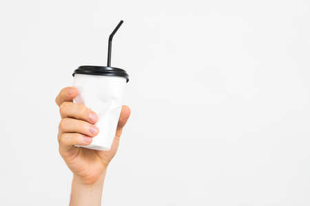 Zero waste. Disposable garbage. Man hand holding paper, plastic cup over white background. Copy space.の写真素材
