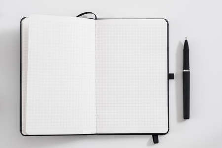 Management and planning. Office worker essentials. Flat lay of blank note book and pen on white...