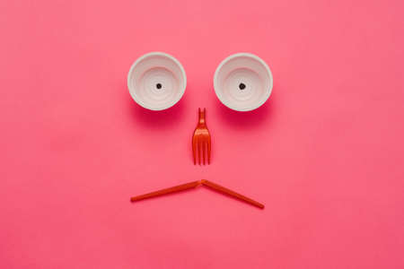 Disappointing ecological reality. Plastic garbage monster face on pink background. Zero waste lifestyle. Copy space.の写真素材