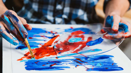 Artist painting. Man hands creating artwork closeup. Red blue paints palette. Inspiration creativity. Hobby therapy relaxationの写真素材