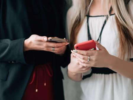 Information technology. Social media addiction. Modern business lifestyle. Female colleagues using...