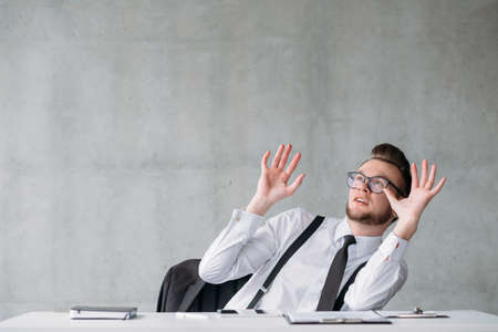 Portrait of young business man scared by imminence of responsibilities. Surprised facial expression.