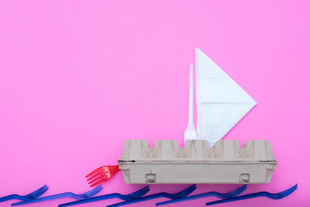 Water pollution. Ecology problem. Garbage ship from carton egg box, paper tissue and disposable...