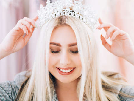 Fashion accessories. Closeup portrait of smiling lady wearing tiara, creating look for special occasion.の写真素材