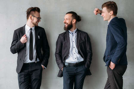 Modern corporate life. Smart confident people. Male colleagues talking, laughing, having fun during...