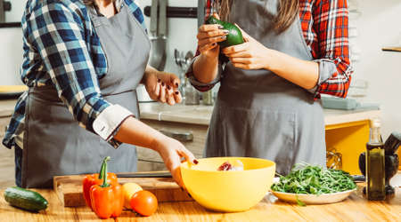 Midsection of women making salad. Healthy balanced eating habit vegan lifestyle. Females dieting preparing fresh veggies.の写真素材