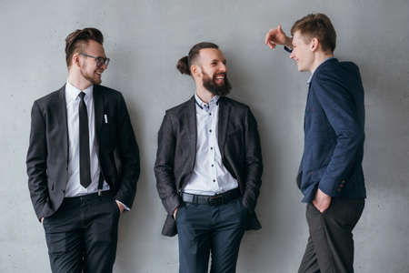 Modern corporate life. Male colleagues having nice conversation during break at work. Successful people lifestyle.の写真素材