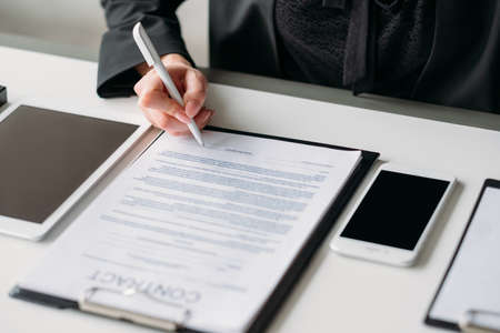 Cooperation and partnership. Business relationship. Closeup of female hand signing contract.の写真素材