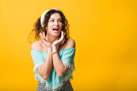Omg wow. Excited young woman looking sideways hands on cheeks mouth open. Surprise interest sale gossip news posture.の写真素材