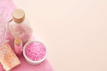 Body treatment and relaxation. Top view of pink bath salt and handmade soap bar on peach background. Copy space.の写真素材