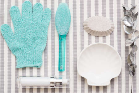 Body skin treatment essentials. Flat lay arrangement of pumice cleaning stone, bath glove, handmade soap on striped background.の写真素材
