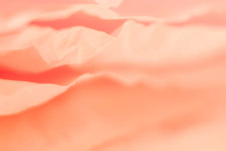 Closeup of pale coral red paper layers stack. Blur abstract art background. Delicate silk texture effect. Copy space.の写真素材