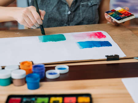 Hobby and creativity. Cropped shot of young female artist painting abstract artwork with watercolor. Copy space.の写真素材