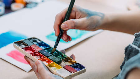 Talent and creativity. Cropped shot of female artist painting abstract artwork with watercolor.の写真素材