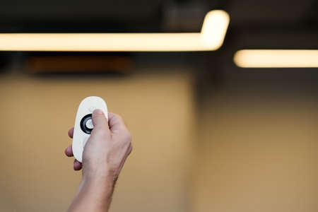 Wireless electronic devices. Closeup of modern design remote control in male hand. Man switching program.の写真素材