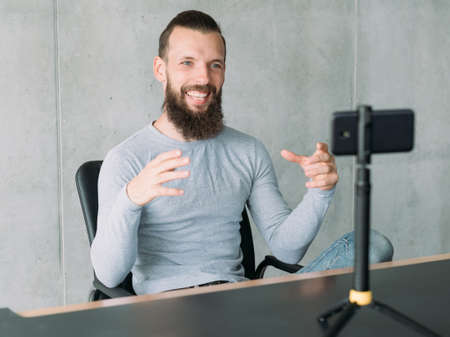 Business coaching. Bearded man telling on camera how to build successful career. Copy space.