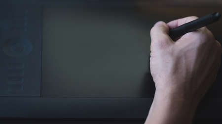 Web design. Top view of illustrator hand drawing with stylus on graphic tablet mockup screen. Copy...