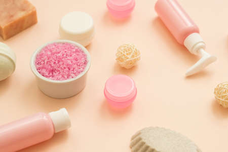 Hygiene and wellness. Flat lay of pink bath salt, handmade soap, cosmetic jars and lotion bottles...