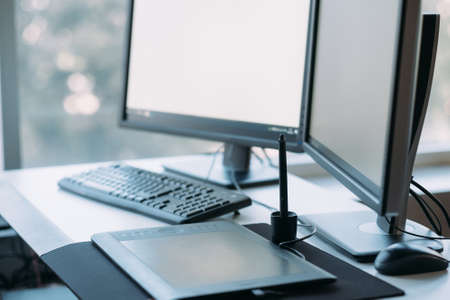 Web graphic design. Creative 3D artist workplace. White mockup monitor screen, tablet, keyboard on...