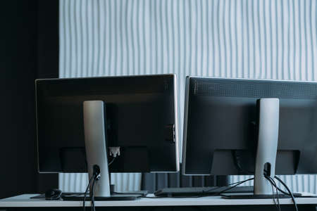Software developer workplace. Two monitors on office desk. Textured wall background. Copy space.の写真素材