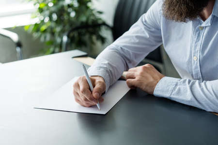Business strategy planning. Cropped shot of bearded man thinking on ideas, holding pen over blank...